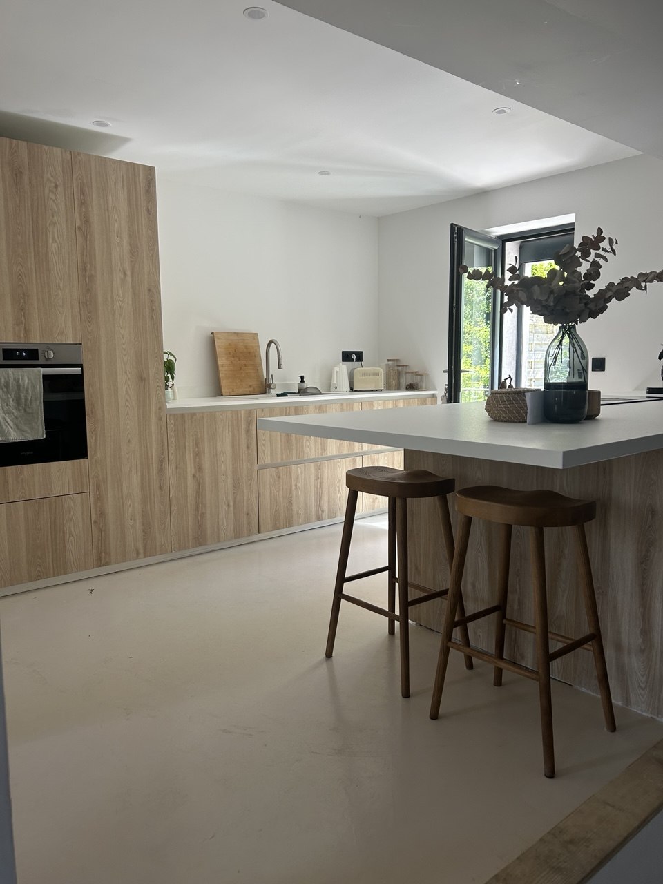 Cuisine avec îlot central et tabourets en bois