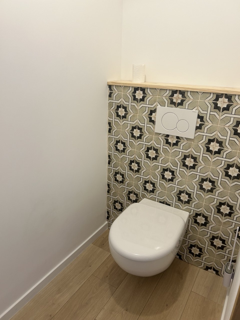 WC suspendu avec mur en carreaux de ciment